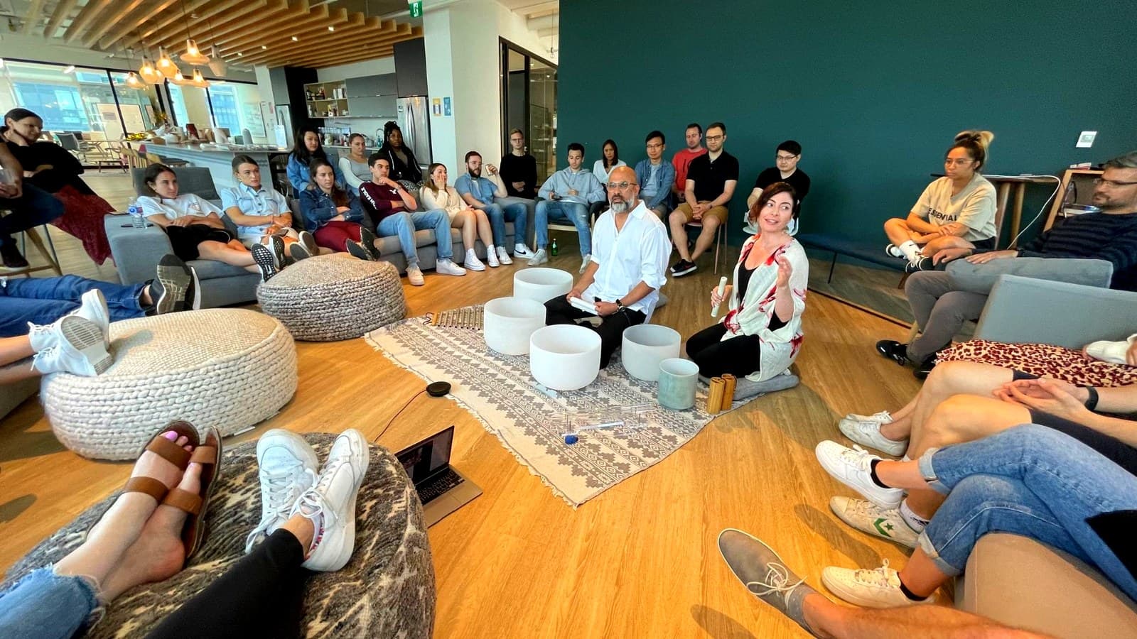 Jennifer and Steve playing to a team seated in a circle in an office lounge