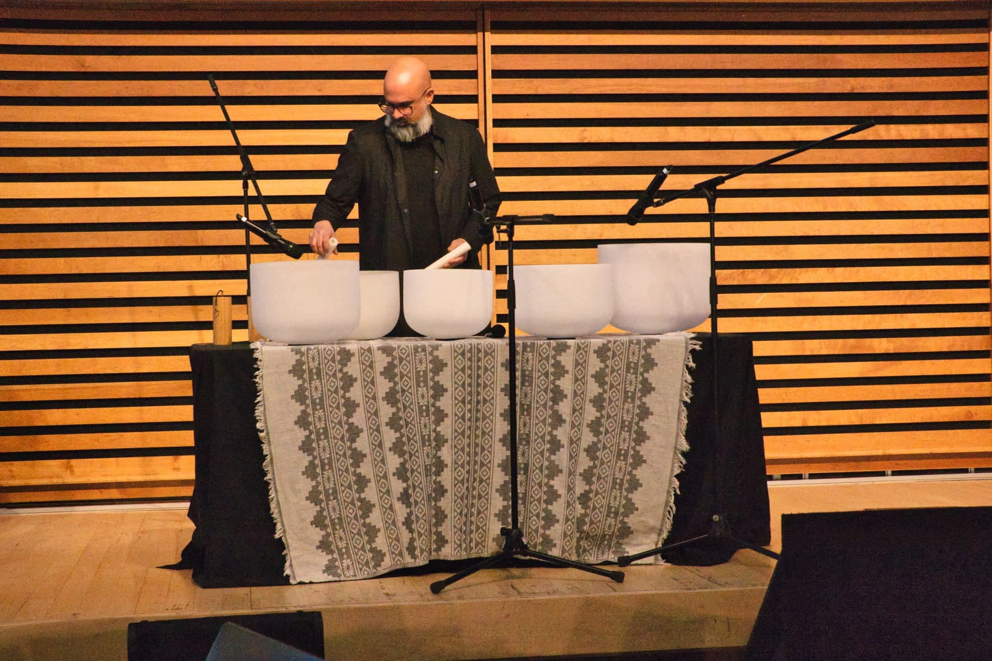 Steve on a conference stage behind a row of crystal bowls, microphones set up in front
