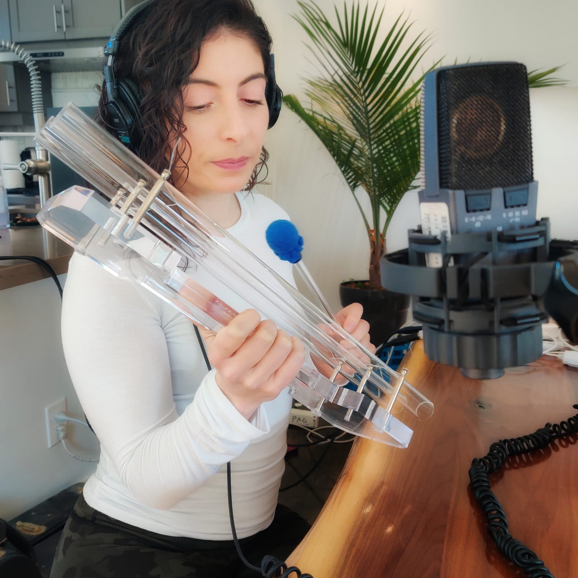 Jennifer at the microphone, playing a set of crystal pipes in the studio